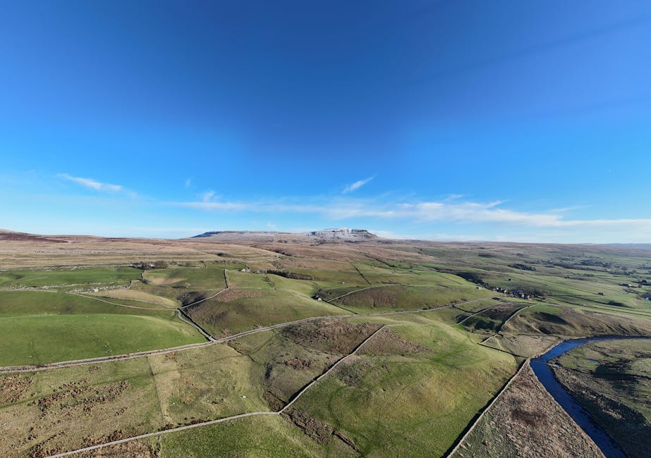 Stunning aerial view of Yorkshire Dales National Park showcasing green fields and clear blue sky.