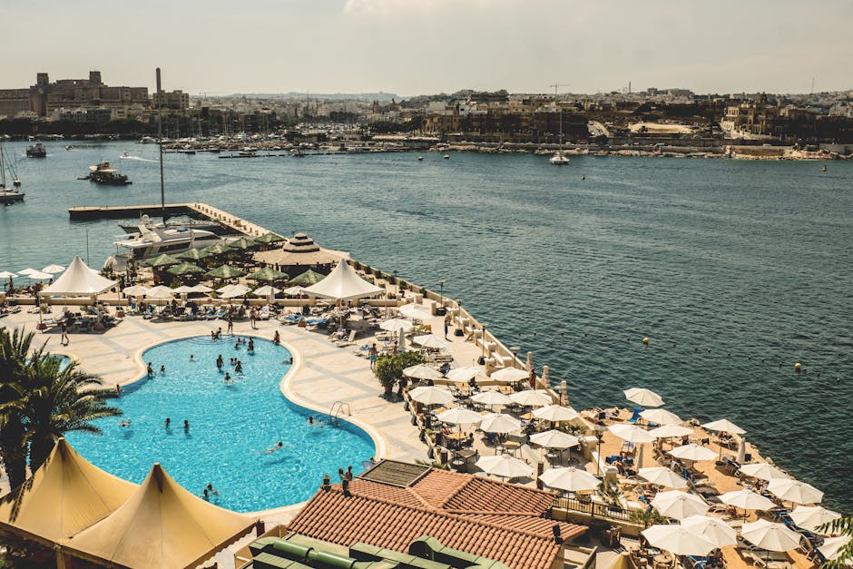 Aerial view of a luxury resort with swimming pool overlooking Mgarr Harbour, Malta.