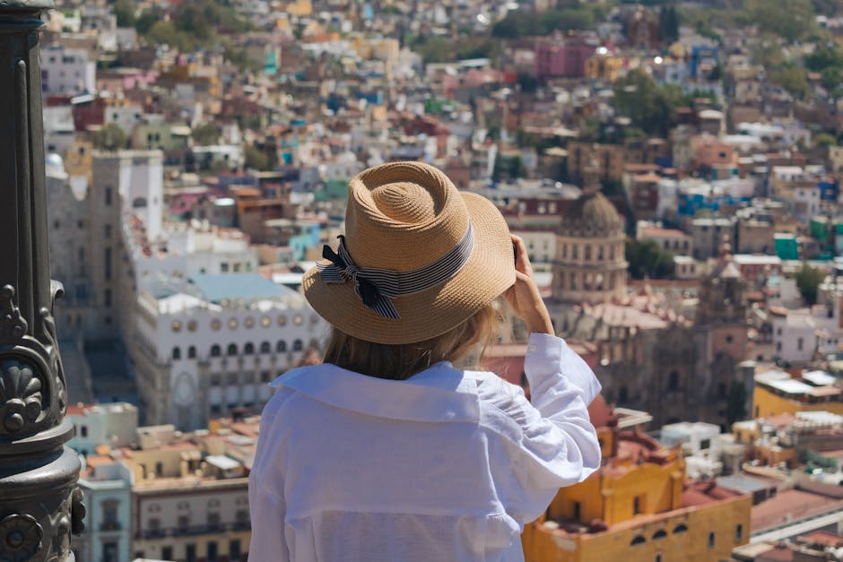 A woman in a hat enjoys the vibrant city view of Guanajuato, Mexico.